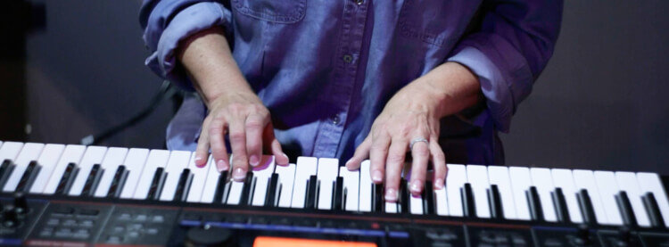 Student playing piano in adult music lesson