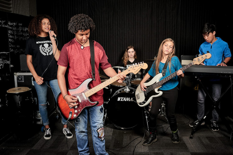 Students learning to play in School of Rock's music programs for teens